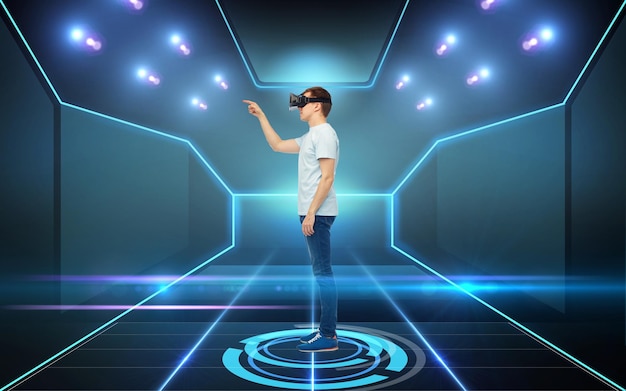 3D-technologie, virtual reality, cyberspace en mensenconcept - jonge man met virtual reality-headset of 3D-bril die een spel speelt over zwarte achtergrond en laserlicht