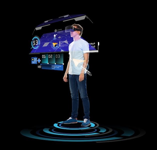 Photo 3d technology, gaming, augmented reality, cyberspace and people concept - happy young man in virtual reality headset or 3d glasses with gps navigator projection over black background