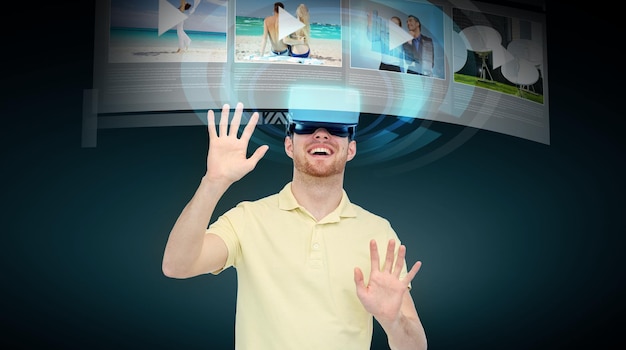 3d 기술, 가상 현실, 사이버 공간, 엔터테인먼트 및 사람 개념 - 가상 현실 헤드셋 또는 3d 안경을 사용하여 검은 배경 위에 있는 미디어 플레이어에서 비디오 레코드를 보는 행복한 청년