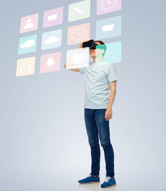 3d technology, virtual reality, entertainment, cyberspace and people concept - happy young man with virtual reality headset or 3d glasses looking at screen with menu icons