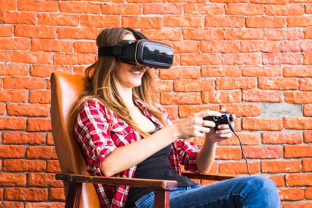 3d technology, virtual reality, entertainment and people concept - happy young woman with virtual reality headset or 3d glasses playing game and fighting