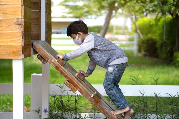 4-5 years old Asian Little boy climbing ladder on playground.