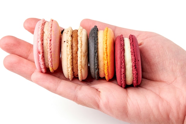 4 color of macarons pink red yellow and creambrown on hand isolated on white background Side view of macaron