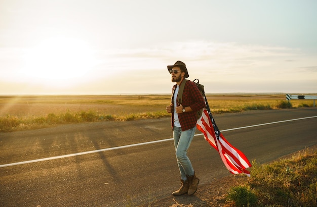 4 juli Amerikaanse vlag reiziger met de vlag van Amerika de man in een hoed een rugzak shirt