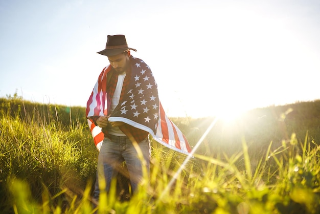 Foto 4 juli amerikaanse vlag reiziger met de vlag van amerika de man in een hoed een rugzak shirt