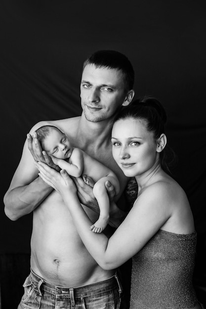 4. Mother and father holding their newborn baby at a newborn photoshoot