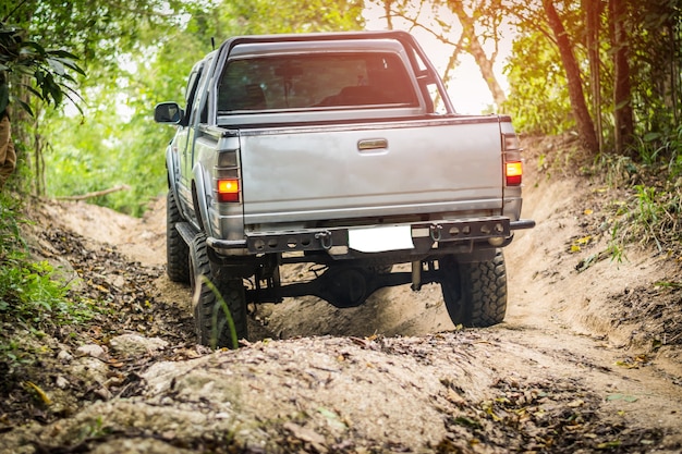 タイの山林では、4輪駆動車が難しいオフロードを登っています。