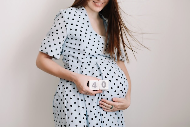 40 weken zwangerschap. Zwangere vrouw buik aan te raken. Gelukkige vrouw zwangerschap, moederschap, lichaamsverzorging. Verwacht een aanstaande baby.