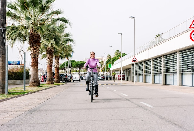전기 자전거를 타고 도시의 거리를 달리는 40 세 여성 (전기 모빌리티 개념)
