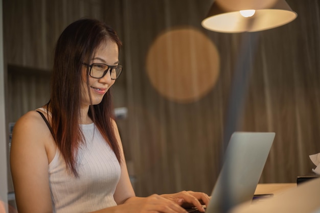 40 years old woman use phone and computer work at home.