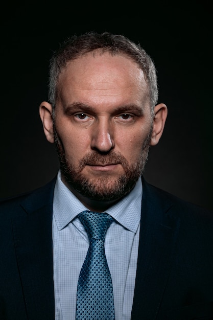 A 40yearold man in a business suit on a black background