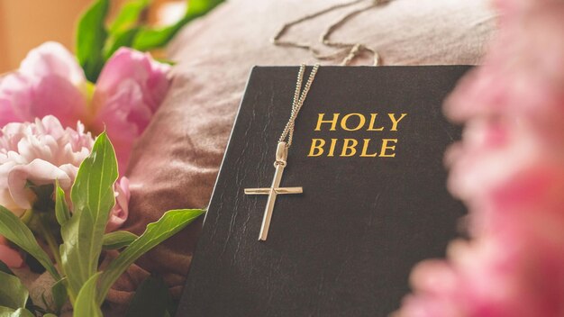 Photo 4k photograph capture closeup of a christian cross and bible adorned with flowers