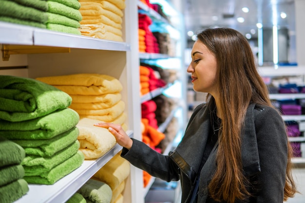 4k shot of a young beautiful woman finding herself new towels in a store supermarket shop.