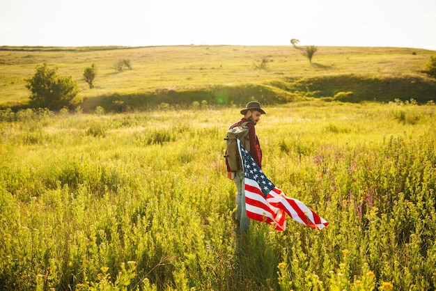 4th of July American Flag Traveler with the flag of America The man in a hat a backpack shirt