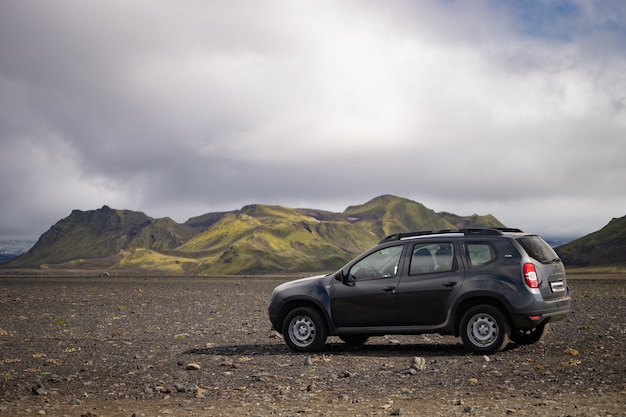 4x4 auto geparkeerd off-road op het zwarte lavaveld op weg naar Landmannalaugar gebied, IJsland.