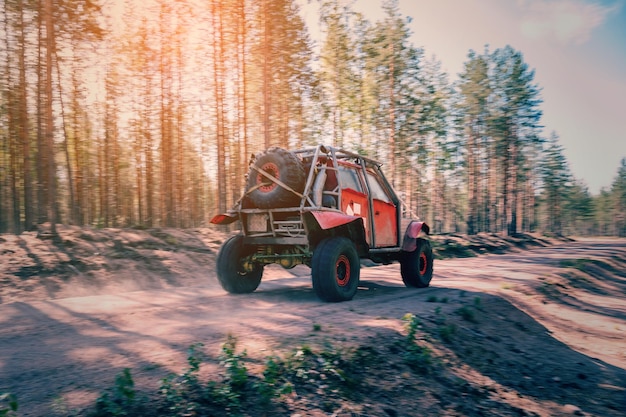 4x4 지프 SUV 자동차가 여름 경주에서 숲의 먼지가 많은 도로에서 빠르게 운전하고 있습니다