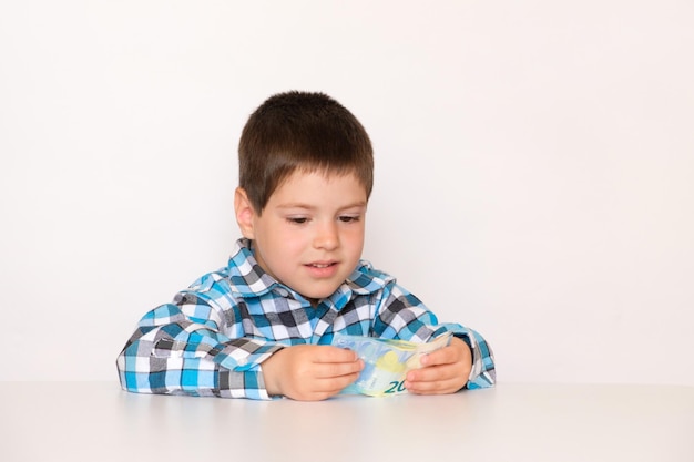 A 4yearold boy counts money holds euros in his hands