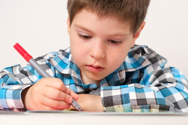 A 4yearold boy draws with a felttip pen on paper