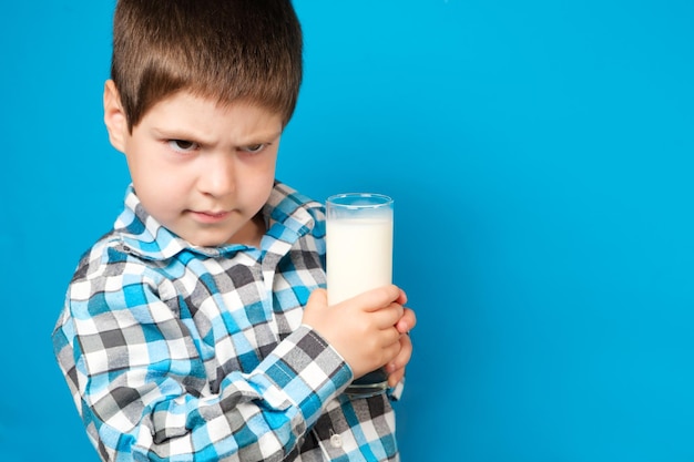 A 4yearold boy holds a glass of milk