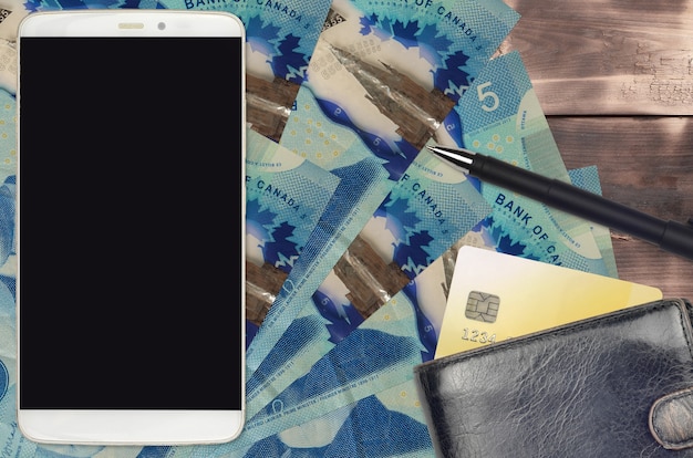 5 Canadian dollars bills and smartphone with purse and credit card