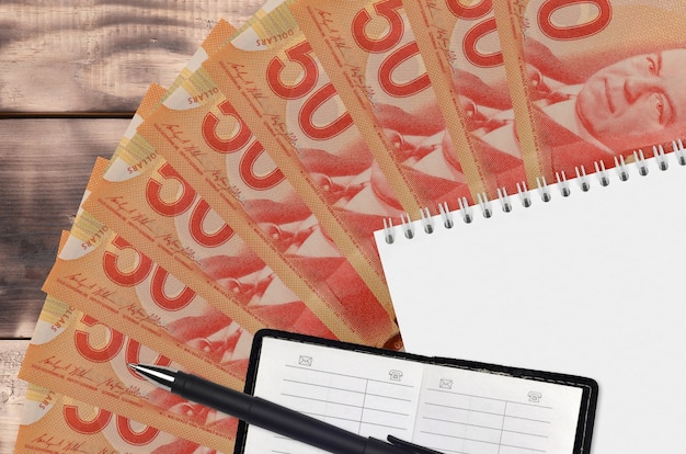 50 Canadese dollar rekeningen ventilator en blocnote met contactboek en zwarte pen