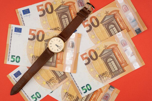 50 euro bills with a clock on a red background