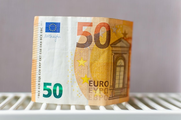 A 50 euro note is on a white rack.