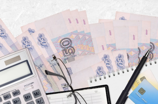50 russische roebelsrekeningen en rekenmachine met glazen en pen