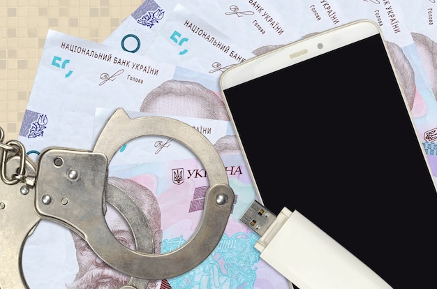 50 Ukrainian hryvnias bills and smartphone with police handcuffs