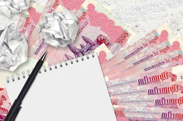 500 Cambodjaanse Riels-biljetten en ballen van verfrommeld papier met blanco notitieblok. Slechte ideeën of minder inspiratieconcept. Op zoek naar ideeën voor investeringen