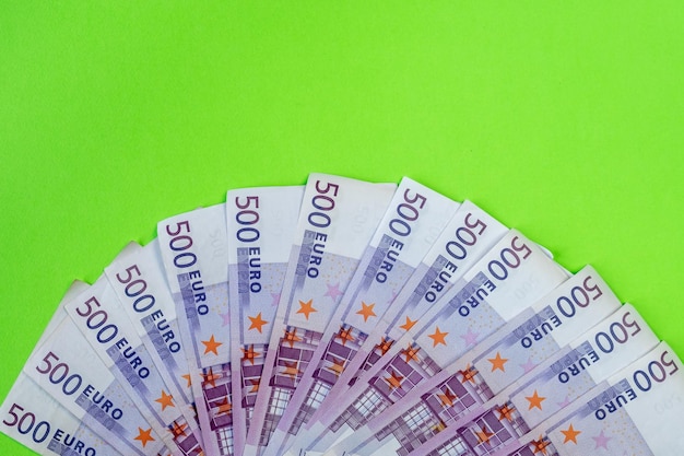 Банкноты 500 евро на зеленом фоне