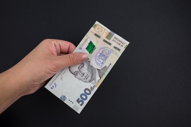 500 hryvnia female in a hand on a black background