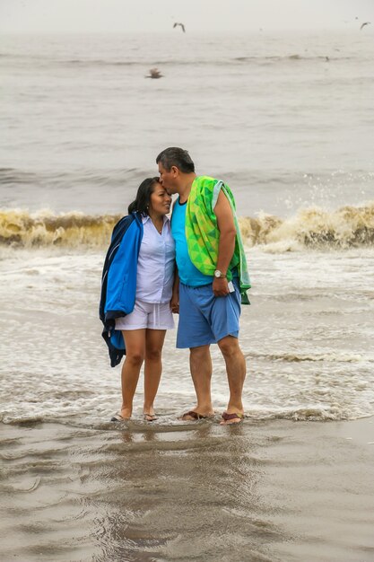 50yearold mature man and woman walk on a beach happy and in love