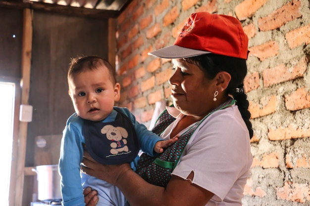 50yearold woman carries a beautiful baby They are both happy grandson and grandmother