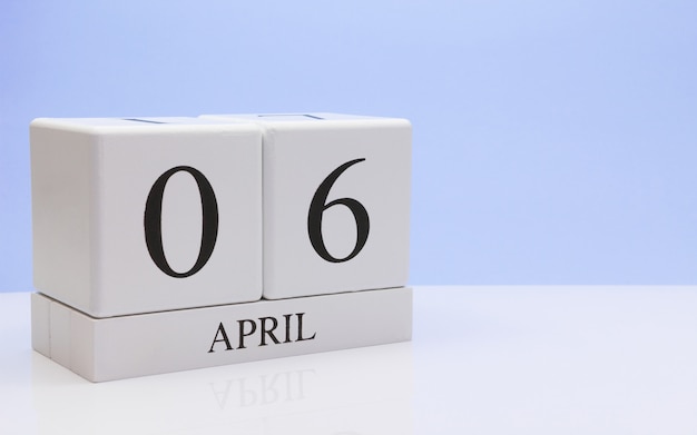 6 april. Dag 06 van de maand, dagelijkse kalender op witte tafel met reflectie