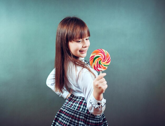 6 of 7 jaar oud kindmeisje dat grote veelkleurige spiraalvormige lollysnoepjes eet