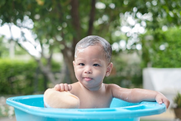 7-месячный ребенок принимает ванну в хорошем настроении на открытом воздухе