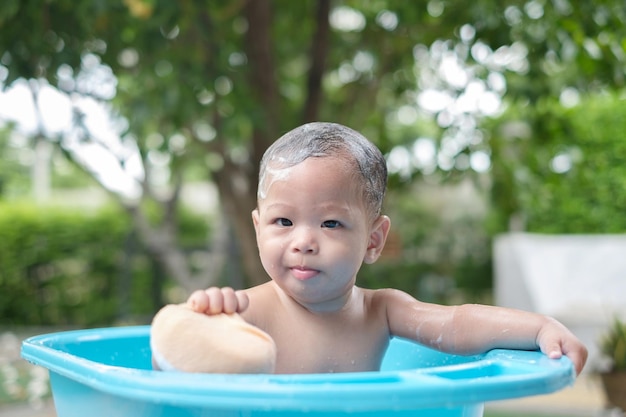 Bambino di 7 mesi che fa il bagno di buon umore all'aperto