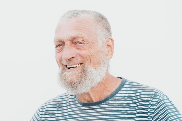 75歳の高齢男性が屋外で楽しい時間を過ごしながら笑っています