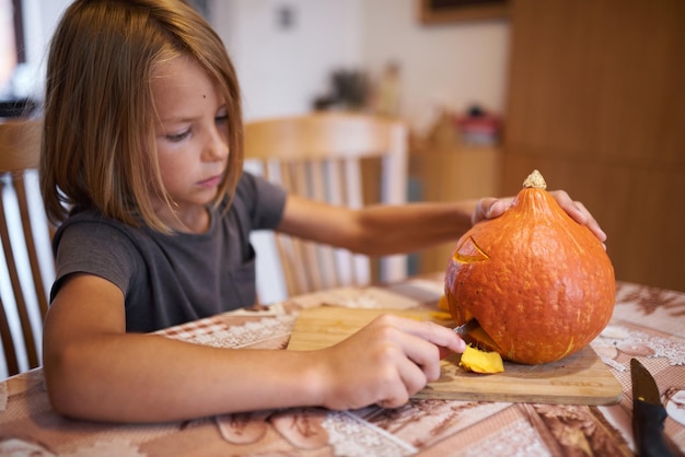 8-jarige jongen die Halloween-pompoen snijdt