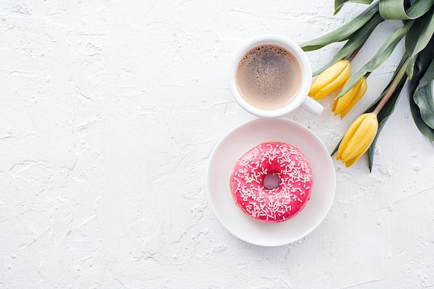 8 maart wenskaartontwerp met een kopje koffie en een schotel met een donut die het nummer acht vormt en een zacht roze tulp in de buurt