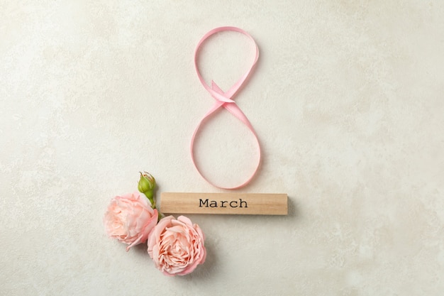 8 made of ribbon, wood block with text March and roses on white textured background