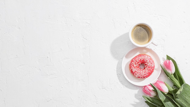 8 march greeting card design with a cup of coffee and a saucer with a donut forming the number eight and a tender pink tulip nearby