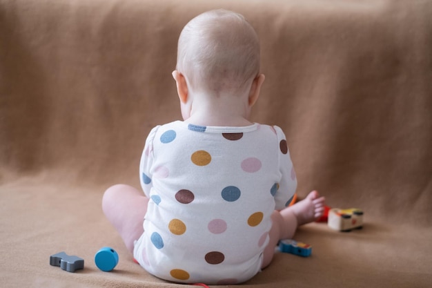 8 month old caucasian baby girl playing with toy at home