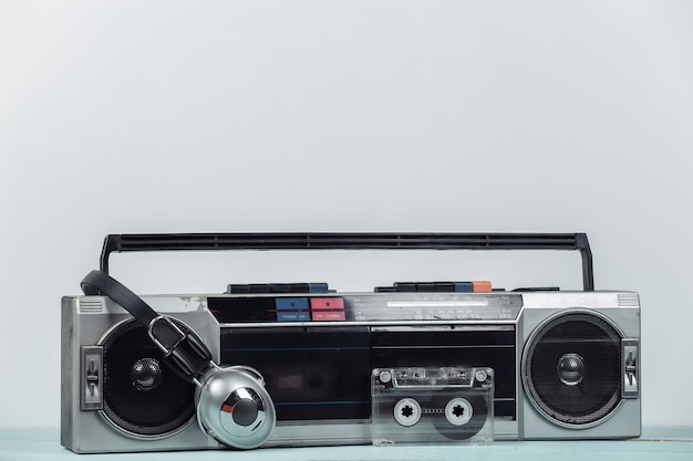 80s retro outdated portable stereo radio cassette recorder,
headphones, audio cassette on white background.