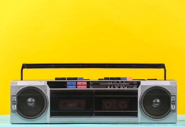 80s Retro verouderde draagbare stereo radio cassetterecorder op gele achtergrond.