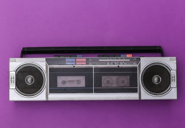 80s retro verouderde draagbare stereo radio cassetterecorder op paarse achtergrond. Bovenaanzicht