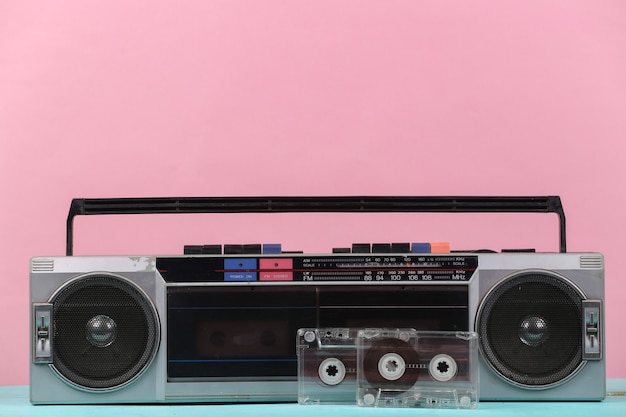 80s Retro verouderde draagbare stereo radiocassette Recorder en audiocassette op roze pastelachtergrond.