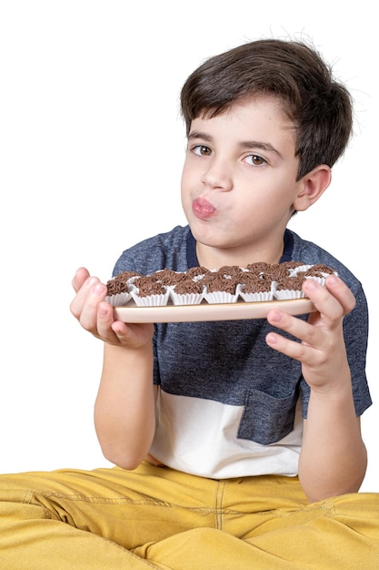 9-jarig kind met een dienblad met verschillende Braziliaanse toffeesballen en tuit haar lippen