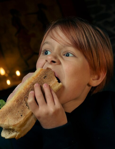 9-jarige jongen die een grote stokbroodsandwich eet